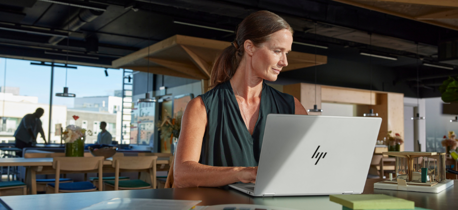 HP Laptop on Table with woman working in a hybrid environment